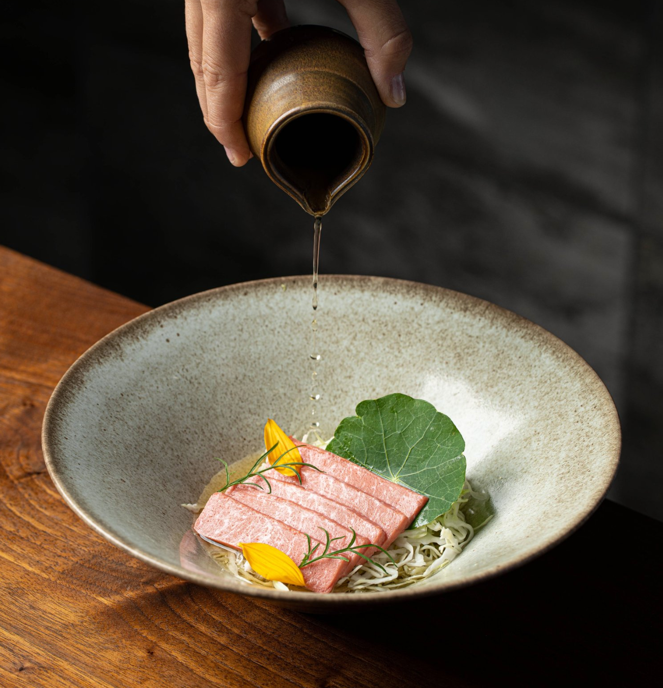 cultivated tuna being served in a dish with sauce