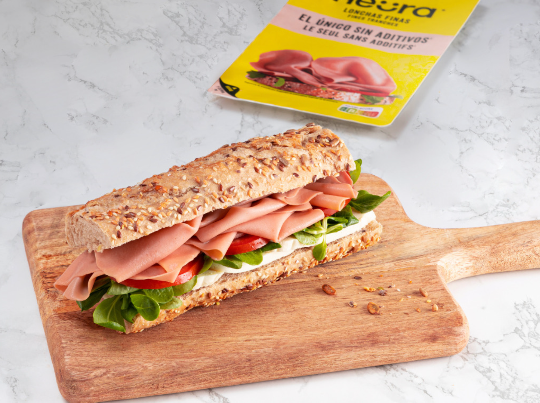 package of plant ham and sandwich on cutting board