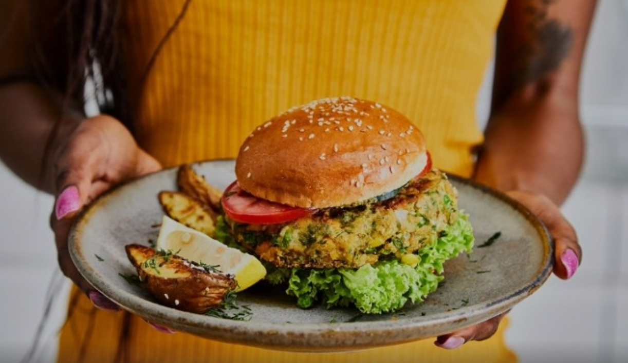 woman holding a plate with veggie burger